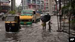 Vehicles move through a waterlogged street during heavy rainfall in Kochi, Kerala state, India, Aug. 7, 2020.