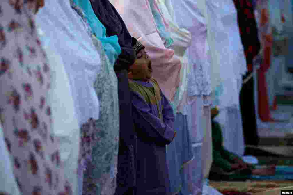 Seorang anak menguap saat mengikuti salah Ied di Pelabuhan Sunda Kelapa, Rabu, 5 Juni 2019. (Foto: Willy Kurniawan/Reuters)