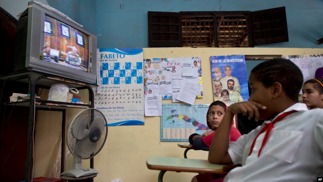 Para pelajar menonton siaran langsung pidato Presiden Kuba Raul Castro mengenai restorasi hubungan dengan Amerika Serikat, dari televisi di sekolah di Havana (17/12). (AP/Ramon Espinosa)