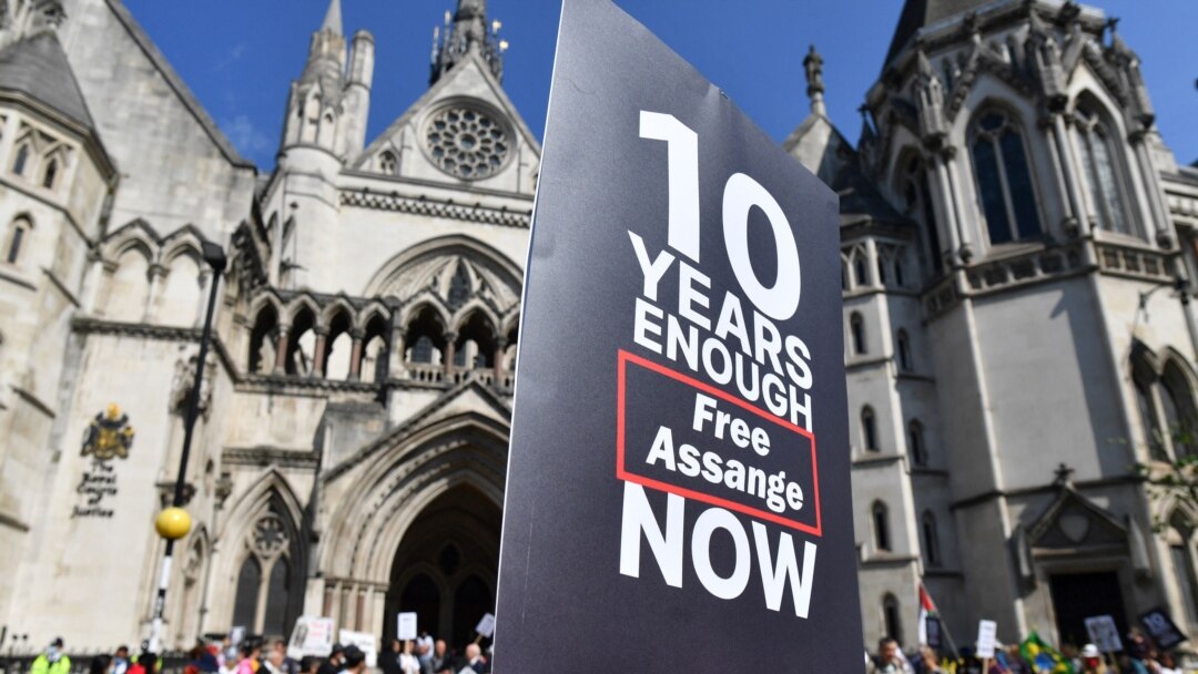 Pendukung dari Julian Assange memegang plakat yang bertuliskan dukungan terhadap pendiri Wikileaks tersebut dalam sebuah unjuk rasa di luar gedung Pengadilan Tinggi di London pada 11 Agustus 2021. Unjuk rasa berlangsung saat pengadilan banding mengenai ekstradisi Assange ke AS digelar. (Foto: AFP)