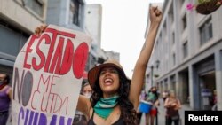 Mujeres feministas protestan en el Día Internacional de la Mujer con un cartel de "El estado no me cuida" en Caracas, Venezuela el 8 de marzo de 2021.