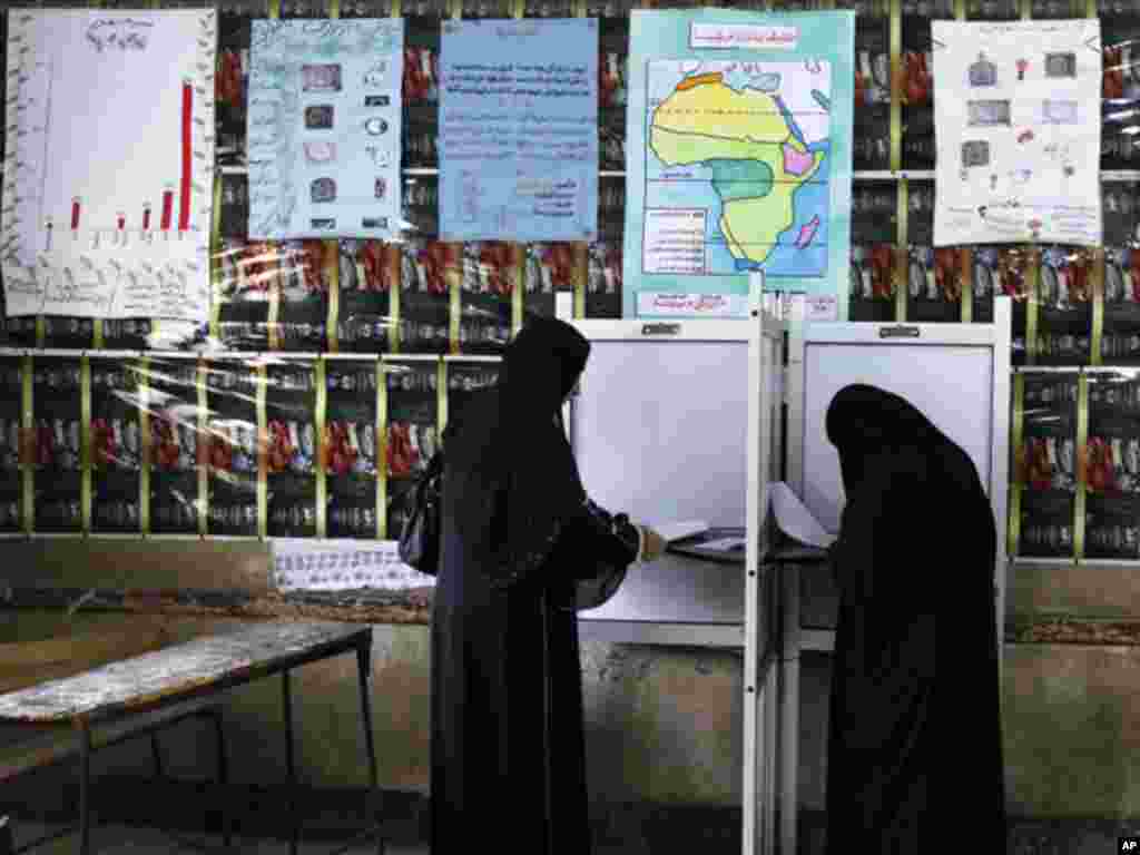 Women read their ballot papers before casting their votes at a polling station at Shubra in El-Kalubia, on the outskirts of Cairo. (Reuters)