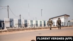 Deux soldats centrafricains patrouillent dans le quartier vide de PK12, à 12 kilomètres du centre-ville de Bangui, le 13 janvier 2021.