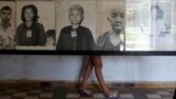 A tourist looks at portraits of victims killed in former Khmer Rouge regime's S-21 security prison, presently known as Tuol Sleng Genocide Museum, Phnom Penh, March 5, 2013.