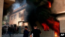 The headquarters of Kurdish Democratic Party burn during a protest by pro-Iranian militiamen and their supporter in Baghdad, Iraq, Oct. 17, 2020. (AP Image)