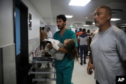 Palestinsku devojčicu ranjenu u izraelskom udaru donose u bolnicu Šifa, u gradu Gaza, 11. oktobra 2023.