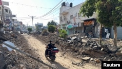 Palestinians ride a motorcycle on a damaged street following an Israeli military operation in Jenin in the Israeli-occupied West Bank Sept. 6, 2024.