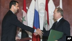 In this Jan. 25, 2005 file photo, Syrian President Bashar Assad, left, and Russian President Vladimir Putin shake hands during a signing ceremony in the Kremlin, Moscow.