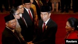 PresidenJoko Widodo (dua dari kanan) didampingi ibu negara, Iriana (kanan) menyalami Menteri Ekonomi yang baru saja dilantik Darmin Nasution (kanan) setelah diambil sumpahnya di Istana Presiden, Jakarta, 12 Agustus 2015 (Foto: REUTERS/Darren Whiteside).