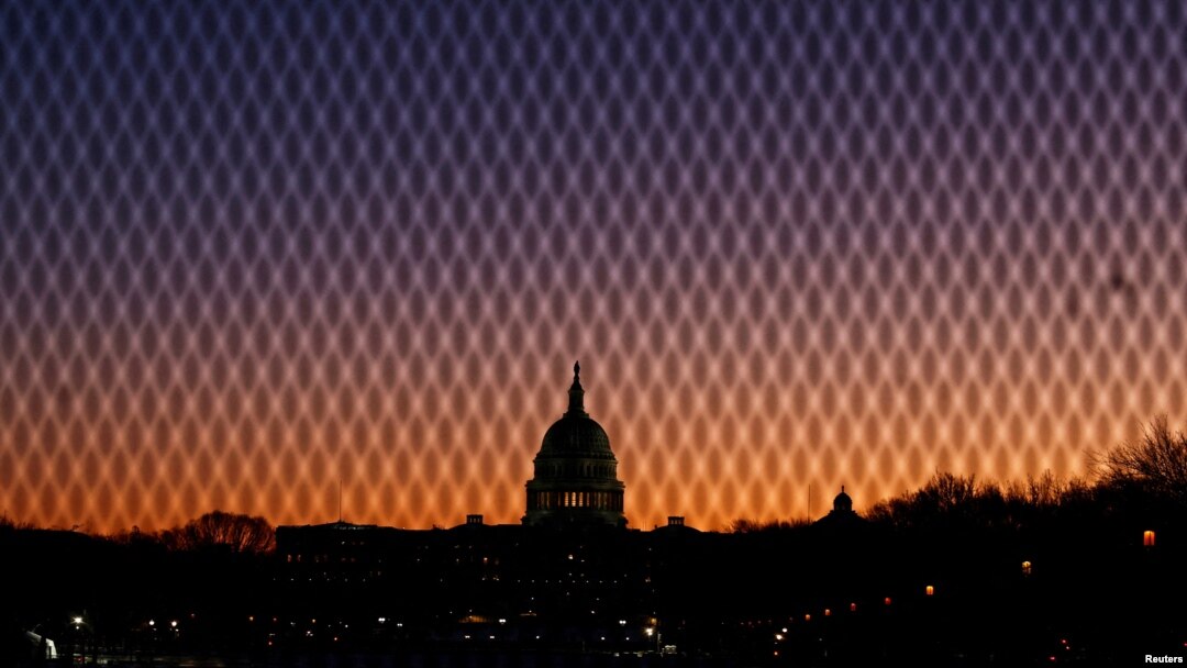 FILE - A security fence stands near the U.S. Capitol as the sun rises in Washington, Jan. 7, 2025.