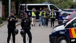 ARCHIVO - Oficiales de policía hacen guardia mientras otros agentes con chalecos amarillos trabajan en el área acordonada junto a la embajada de Ucrania en Madrid, España, el 30 de noviembre de 2022, luego de informes de una explosión en la embajada de Ucrania. 