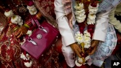 FILE - An Indian couple, from impoverished families, sit beside each other during a mass marriage ceremony in New Delhi, India.