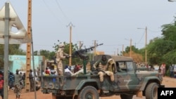 FILE—Malian soldiers ride on a pick-up truck with a machine gun after a suicide car bomb attack overnight by the GSIM jihadist group in Gao, November 13, 2018.