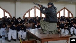 A Pakistani security official poses as a militant during a security drill Feb. 2 at the Islamia College in Peshawar.