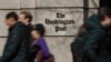 FILE - People walk by the One Franklin Square Building, home of The Washington Post newspaper, in downtown Washington, Feb. 21, 2019. 