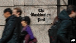 FILE - People walk by the One Franklin Square Building, home of The Washington Post newspaper, in downtown Washington, Feb. 21, 2019. 