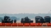 FILE - Myanmar's military stand guard at a checkpoint manned with an armored vehicles blocking a road leading to the parliament building, Feb. 2, 2021, in Naypyitaw. 