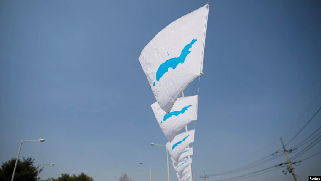 Bendera unifikasi berkibar dihembus angin di Jembatan Persatuan Besar (Grand Unification) menuju Gedung Perdamaian (Peace House), tempat pertemuan antar-Korea, dekat zona demiliterisasi yang memisahkan kedua Korea di Paju, Korea Selatan, 25 April 2018.