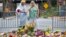Women visit a memorial at 4th and Water Streets, Aug. 15 2017, in Charlottesville, Va., where Heather Heyer was killed when a car rammed into a group of counterprotesters last weekend. 