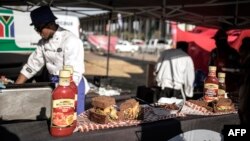 Un marchand de rue prépare un sandwich "Kota" lors du festival de Kota, à Kliptown, à Soweto, le 8 septembre 2018.