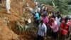 Residents of Bududa cut through trees and timber on June 26, 2012 as they try to get to victims of a mudslide in eastern Uganda, about 200 kilometers from the capital Kampala.