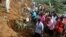 Residents of Bududa cut through trees and timber on June 26, 2012 as they try to get to victims of a mudslide in eastern Uganda, about 200 kilometers from the capital Kampala.