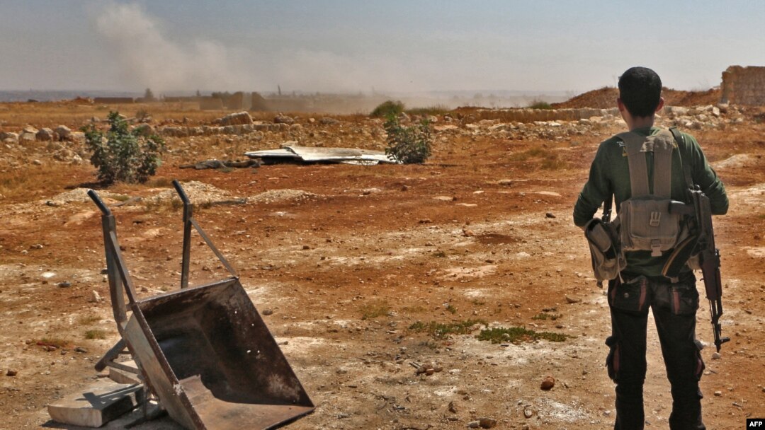 A Syrian rebel fighter watches smoke rising from an explosion at an unknown location in Idlib province, Sept. 5, 2018. The Russian military confirmed that airstrikes were carried out on Syria's last major rebel stronghold of Idlib.