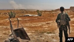 A Syrian rebel fighter watches smoke rising from an explosion at an unknown location in Idlib province, Sept. 5, 2018. The Russian military confirmed that airstrikes were carried out on Syria's last major rebel stronghold of Idlib.