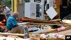 Charles Milam takes a break while searching his destroyed home on Clayton Avenue in Tupelo, Mississippi, April 29, 2014. Milam, his wife and his granddaughter were at home at the time of the tornado, and all survived.