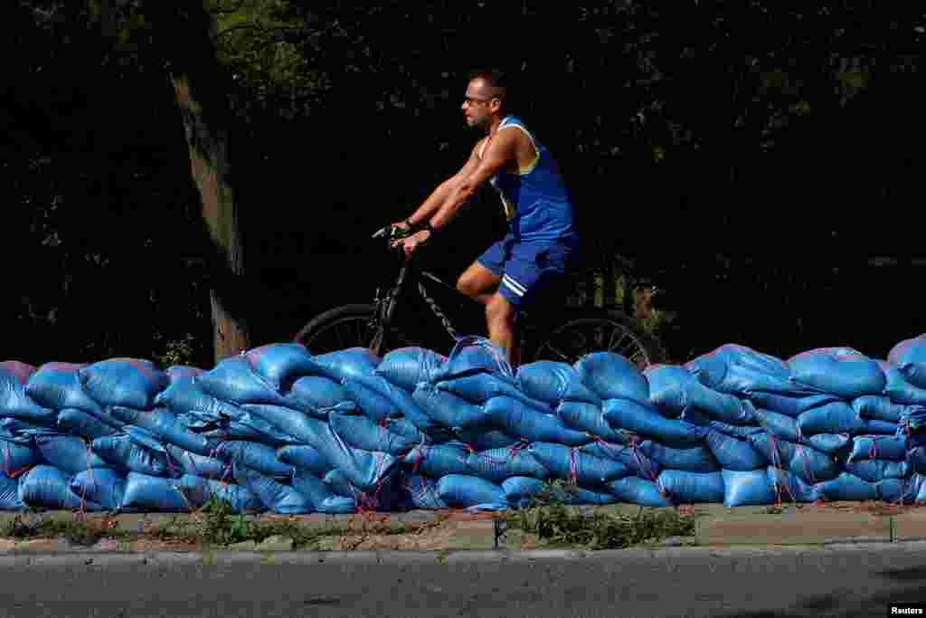 A man rides a bike near sandbags protecting buildings and streets against the flooding of the Bystrzyca River in Wroclaw, Poland.