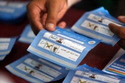 FILE - An Afghan election commission worker sort ballots for an audit of the presidential run-off votes at an election commission office in Kabul, Aug. 25, 2014.