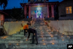 Hindus light candle outside the stairs of a temple as they celebrate Diwali, the Hindu festival of lights in Srinagar, Indian controlled Kashmir, Monday, Oct. 24, 2022. (AP Photo/Mukhtar Khan)