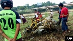 Warga memperhatikan rongsokan pesawat jet militer yang mengalami kecelakan, di sebuah lapangan di Magway, Selasa, 16 Oktober 2018.