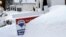 Un cartel de venta de una casa casi tapado por la nieve en Marlborough, Massachusetts.