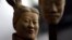 FILE - A female terracotta soldier statue holds the mask of a man as it stands in an army made up of women and children at an art gallery in Beijing, Feb. 24, 2007. Women in China say they are seeing an eroding of their status from the days of Mao Zedong