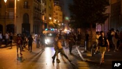 Manifestantes anti-governo atiram pedras contra a polícia anti-motim, em Beirute, 6 de agosto