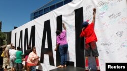 Para penggemar almarhum Muhammad Ali menandatangani spanduk raksasa dalam acara "I Am Ali" untuk merayakan kehidupan sang juara di Kentucky Center of the Performing Arts, Louisville, Kentucky (8/6).