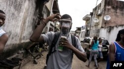 Un homme porte un masque à gaz lors de manifestations encouragées par l'église catholique à Kinshasa, le 25 février 2018.