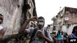 Un homme porte un masque à gaz lors de manifestations encouragées par l'église catholique à Kinshasa, le 25 février 2018.