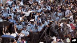 Polisi anti huru-hara Hong Kong menjaga komplek pemerintahan dari demonstran pro demokrasi.