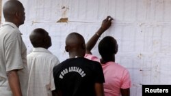 Des électeurs regardent les noms sur un mur au bureau de vote de Kisumu, Kenya, le 6 août 2017.