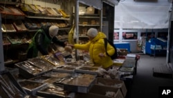 FILE - A woman buys from a vendor at a market in Kyiv, Ukraine, on Jan. 30, 2023. The U.S. Treasury Department on Dec. 10, 2024, transferred $20 billion to a World Bank fund, part of a larger loan to Ukraine for economic and financial aid.