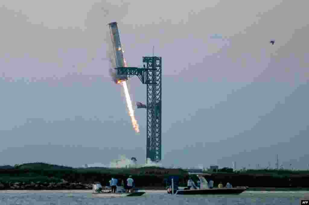 Starship&#39;s Super Heavy Booster is grappled at the launch pad in Starbase near Boca Chica, Texas, Oct. 13, 2024, during the Starship Flight 5 test.&nbsp;&nbsp;SpaceX successfully &quot;caught&quot; the first-stage booster of its Starship megarocket as it returned to the launch pad after a test flight, a world first in the company&#39;s quest for rapid reusability.