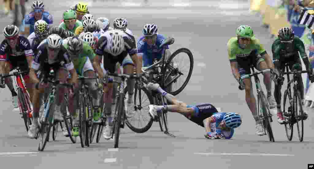 Andrew Talansky of the U.S. crashes as the pack with stage winner Italy&#39;s Matteo Trentin, foreground left, sprints towards the finish line during the 7th stage of the Tour de France.