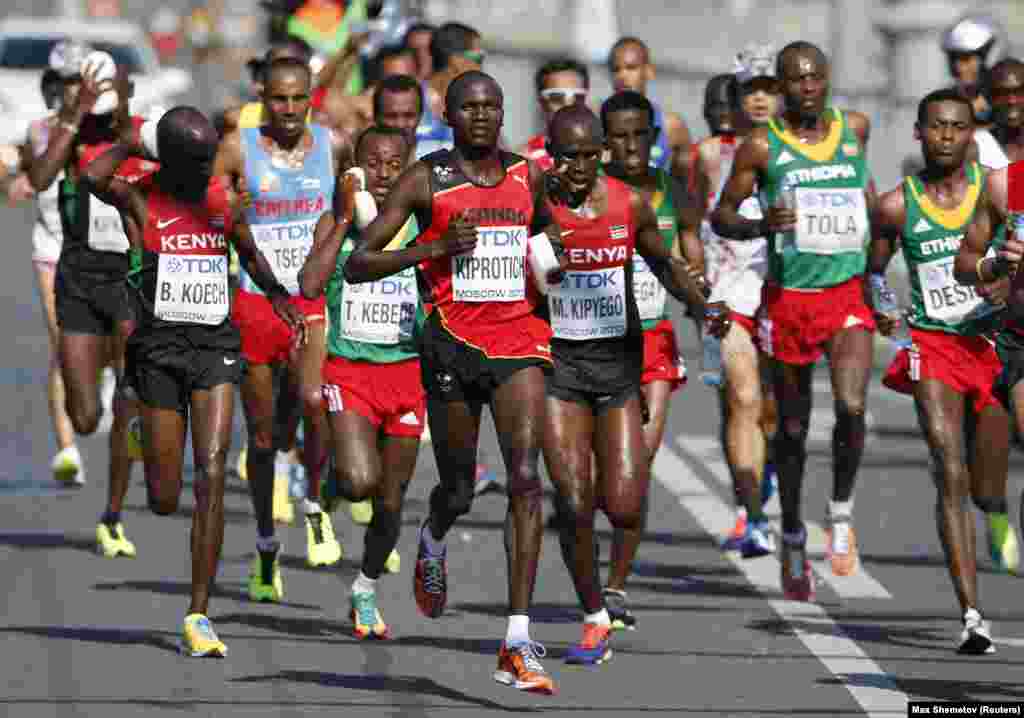 Stephen Kiprotich of Uganda (C) holds a sponge as he runs through the streets of Moscow during the men's marathon at the IAAF World Athletics Championships August 17, 2013. REUTERS/Max Shemetov (RUSSIA - Tags: SPORT ATHLETICS) - RTX12ONY