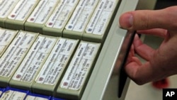 A researcher at the United Nations in New York opens a drawer containing some of the 184 reels of microfilmed documents containing data on World War II criminals, Feb. 23, 2012. Starting Friday, the general public can search a catalog of documents online.