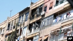 Damaged houses are seen during a heavy firefight that broke out between rebels and the Syrian government army at the western neighborhood of al-Mezze in Damascus, March 19, 2012