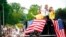 Olympian Sunisa Lee, center, waves from a St. Paul fire truck with her mom Yeev Thoj, left, and sister Shyenne Lee as fans cheer for her along the White Bear Ave. parade route, Sunday, Aug. 8, 2021, in St. Paul, Minn. Minnesota celebrated the Olympic…
