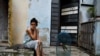 Una mujer se sienta afuera con su loro mientras Cuba sufre un apagón en toda la isla, en La Habana, Cuba, el 18 de octubre de 2024. REUTERS/Norlys Perez.