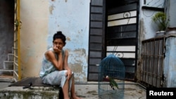 Una mujer se sienta afuera con su loro mientras Cuba sufre un apagón en toda la isla, en La Habana, Cuba, el 18 de octubre de 2024. REUTERS/Norlys Perez.